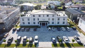 an aerial view of a large white building with parked cars at Hotel Sleep & Dream Nähe Europa Park und Rulantica in Ringsheim