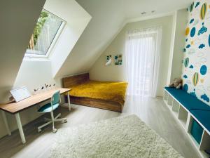 1 dormitorio con cama, escritorio y ventana en Villa Toscana en Gietrzwałd