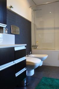 een badkamer met een wastafel, een toilet en een bad bij FeelCoimbra Apartment Mondego in Coimbra