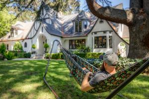 a man sitting in a hammock in front of a house at Candlelight Inn Napa Valley in Napa