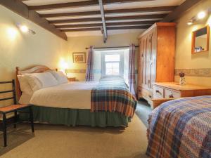 a bedroom with two beds and a window at Milkwood Cottage in Fishguard