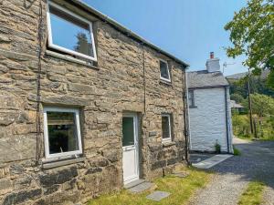 an old stone house with a white door at Ty Cynon in Blaenau-Ffestiniog