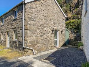 a stone building with a door and a stairway outside at Ty Cynon in Blaenau-Ffestiniog
