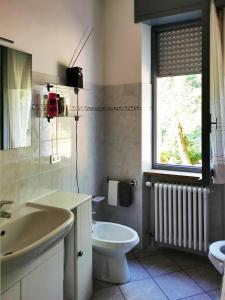 a bathroom with a sink and a toilet and a window at La casa gentile appartamento Aurora in Roccaverano