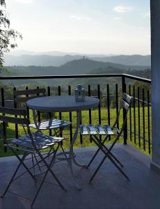 a table and two chairs on a balcony with a view at La casa gentile appartamento Aurora in Roccaverano