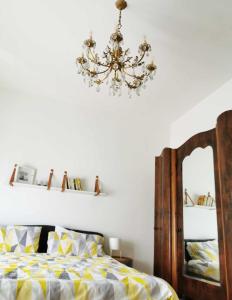 a bedroom with a bed and a chandelier at La casa gentile appartamento Aurora in Roccaverano