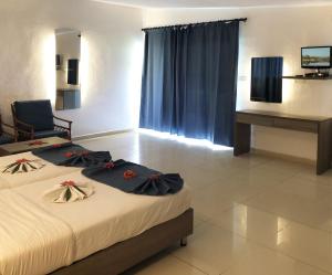 a hotel room with two beds and a desk at Palma Rima Hotel in Kololi