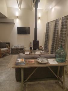 UrallaThe Bower@ Kings Cottage的客厅设有木桌和壁炉