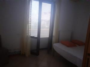 um pequeno quarto com uma janela com uma persiana em A due passi dal mare em Porto Recanati