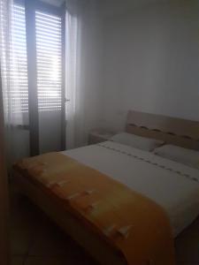 um quarto com 2 camas e uma janela com persianas em A due passi dal mare em Porto Recanati