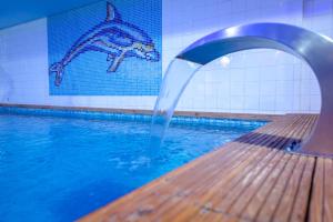 a pool with a water fountain in a swimming pool at Les Pins Blancs en Provence in Le Muy