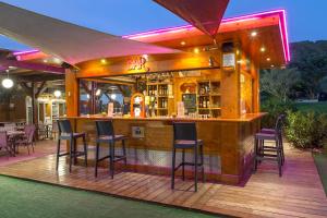 - un bar sur une terrasse entourée de chaises dans l'établissement Les Pins Blancs en Provence, au Muy