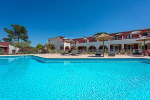 a large blue swimming pool in front of a building at Les Pins Blancs en Provence in Le Muy