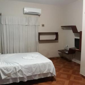 - une chambre avec un lit blanc et un escalier dans l'établissement Pousada Gincoara, à Jericoacoara