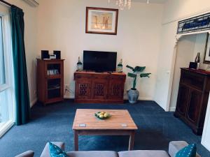 a living room with a tv and a table at Weeroona Bed And Breakfast in Rye