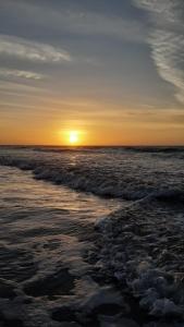 una puesta de sol en una playa con el océano en Casa de praia, Camocim., en Camocim