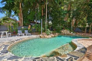 una piscina en un patio con 2 sillas y una mesa en Decked Out By The Sea, en Clifton Beach