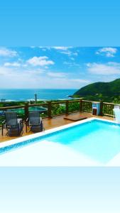 - une piscine avec des chaises et une vue sur l'océan dans l'établissement Pousada Moradas da Silveira, à Garopaba