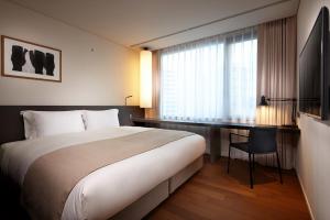 a hotel room with a large bed and a desk at Shilla Stay Mapo Hongdae in Seoul