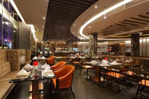 a restaurant with tables and chairs and a bar at Crowne Plaza Kunming City Centre by IHG in Kunming