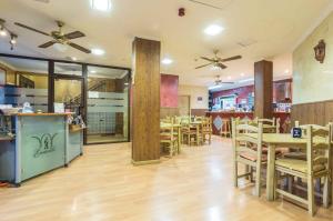 une salle à manger avec des tables et des chaises dans un restaurant dans l'établissement Hotel Esmeralda, à Osuna