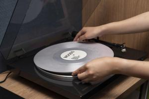 una persona está sosteniendo un CD en una máquina en Umekoji Potel KYOTO, en Kioto