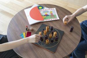 a child playing with a table with a book and toys at Umekoji Potel KYOTO in Kyoto