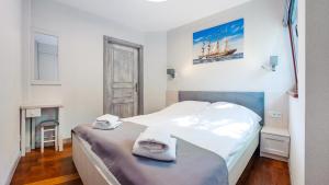 Un dormitorio con una cama con toallas. en Willa na Wydmach, en Jurata