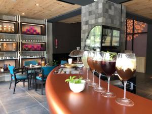 a group of wine glasses sitting on a bar in a restaurant at Comin' Place in Wuri