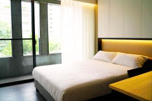 a bedroom with a large bed and a window at Comin' Place HSR Hotel in Wuri