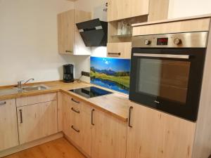 una cucina con lavandino e piano cottura forno superiore di Apartment Beim Raffner a Ruhpolding