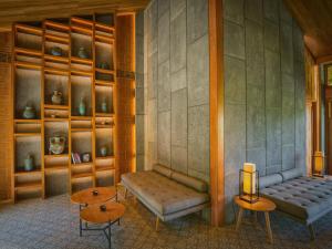 a room with a bench and shelves with vases at Legacy Mekong, Can Tho, Autograph Collection in Can Tho +113 photos