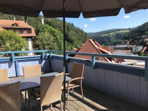a balcony with a table and chairs and an umbrella at Stilvolle Ferienwohnung im Herzen von Triberg in Triberg