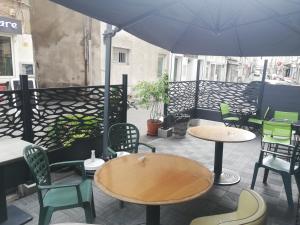 a patio with tables and chairs and an umbrella at Bar Times Square in Vienne
