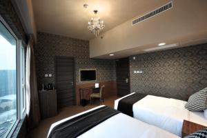 香港にあるRamada Hong Kong Grandのベッドルーム1室(ベッド2台、デスク、シャンデリア付)