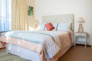 a bedroom with a large bed with pillows on it at A Little Getaway in South West Rocks