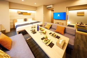 pokój hotelowy z dwoma łóżkami i telewizorem w obiekcie MONday Apart Premium 浜松町 w Tokio