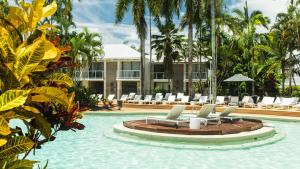 un complejo con piscina con sillas y un edificio en Oaks Port Douglas Resort, en Port Douglas