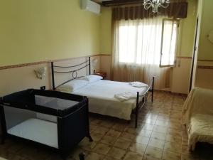 a bedroom with a bed and a chair and a window at Hotel La Carina in Grottaminarda