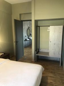 a bedroom with a bed and a bathroom with a mirror at Petousis Hotel & Suites in Amoudara Herakliou