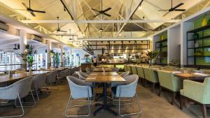 un restaurante con mesas y sillas de madera y un bar en Oaks Port Douglas Resort en Port Douglas