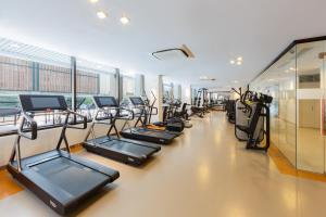 un gimnasio con una fila de cintas de correr y elípticas en SILA Urban Living, en Ho Chi Minh
