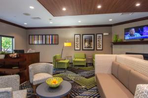 a living room filled with furniture and a tv at Holiday Inn Express and Suites Springfield Medical District, an IHG Hotel in Springfield