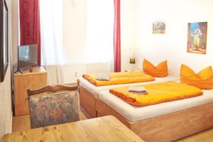um quarto com duas camas e uma mesa e uma televisão em Gwuni Mopera em Leipzig