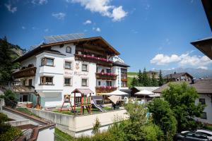 a hotel with solar panels on the roof at Ferienhotel Angerhof in Fiss