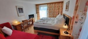 a small bedroom with a bed and a red couch at Ferienwohnung Spitzmandl in Innsbruck