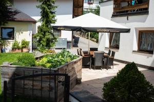 a patio with an umbrella and a table and chairs at Angerhof Apartment in Fiss
