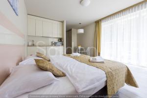 sypialnia z 2 łóżkami z białą pościelą i oknem w obiekcie Apartament Czarna Góra Sienna SOL w mieście Sienna