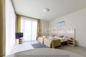 sypialnia z łóżkiem i telewizorem w obiekcie Apartament Czarna Góra Sienna SOL w mieście Sienna