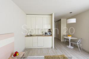kuchnia z białymi szafkami i stołem w pokoju w obiekcie Apartament Czarna Góra Sienna SOL w mieście Sienna